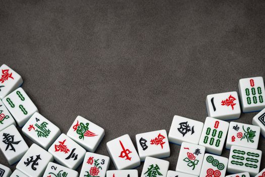 A collection of traditional Mahjong tiles arranged on a grey surface, perfect for board game concepts.