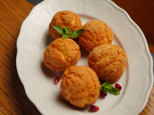 Free Golden pastry puffs garnished with mint and pomegranate on a white plate. Stock Photo