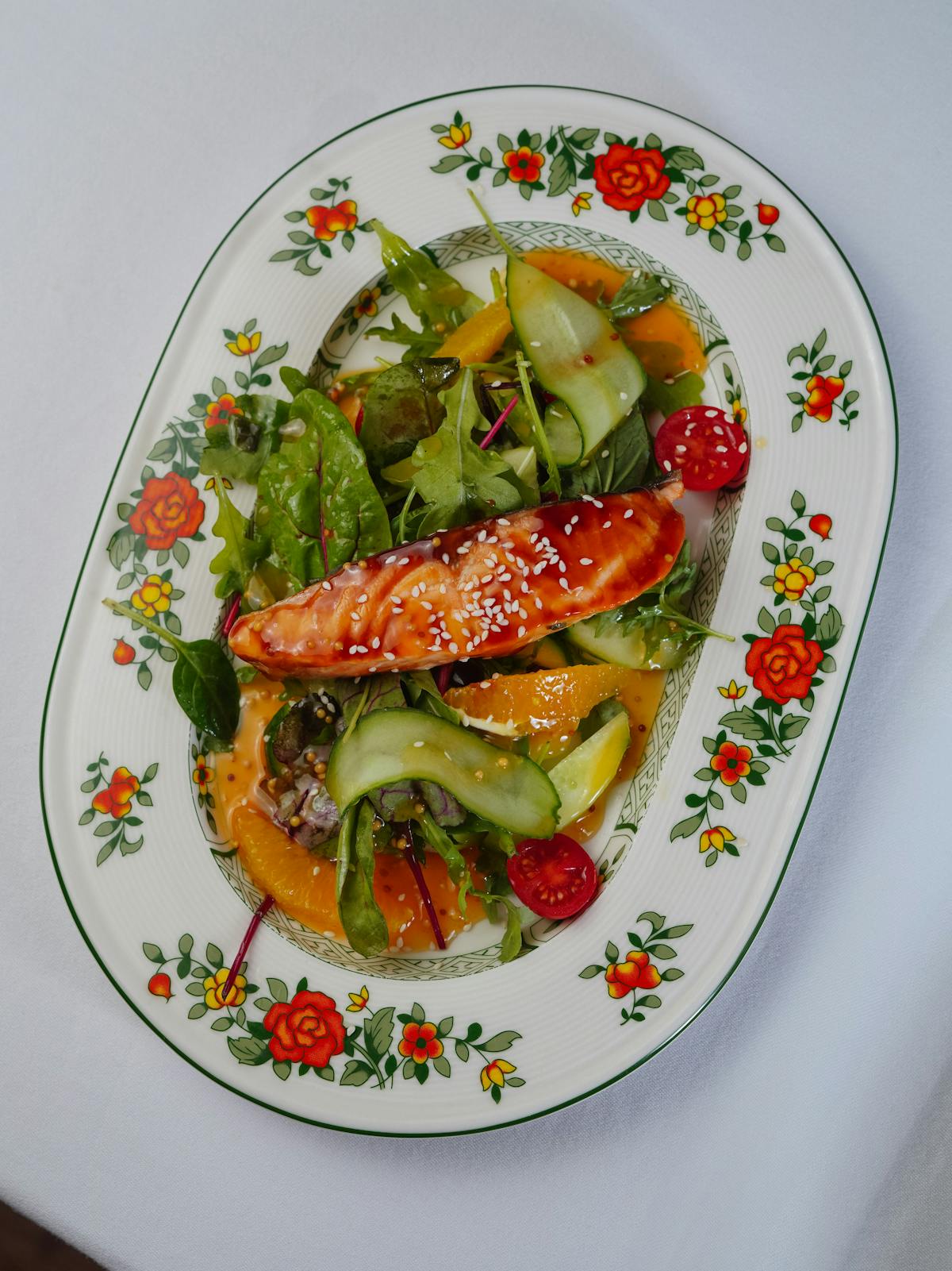 Insalata colorata con salmone, fette di agrumi e verdure a foglia