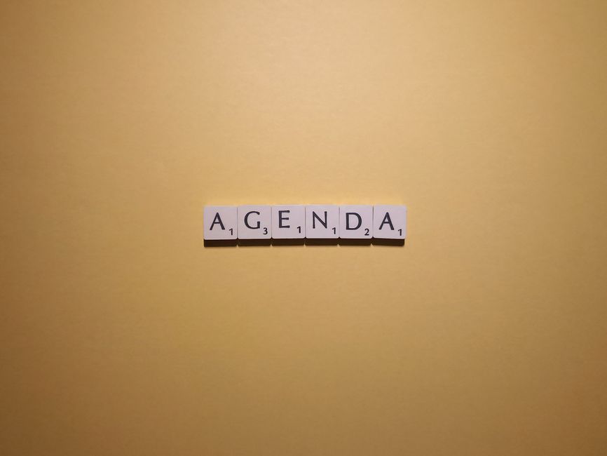 Scrabble tiles spelling 'Agenda' on a simple yellow background. Perfect for planning or organization themes.