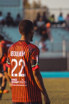 Soccer player wearing striped jersey with number 22 on outdoor field.