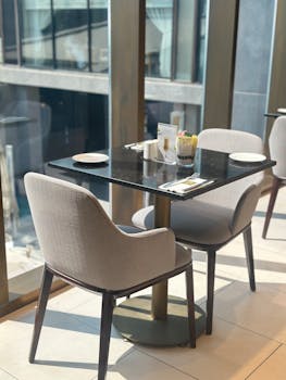 Elegant restaurant table by window with city view. Perfect for dining stock imagery.
