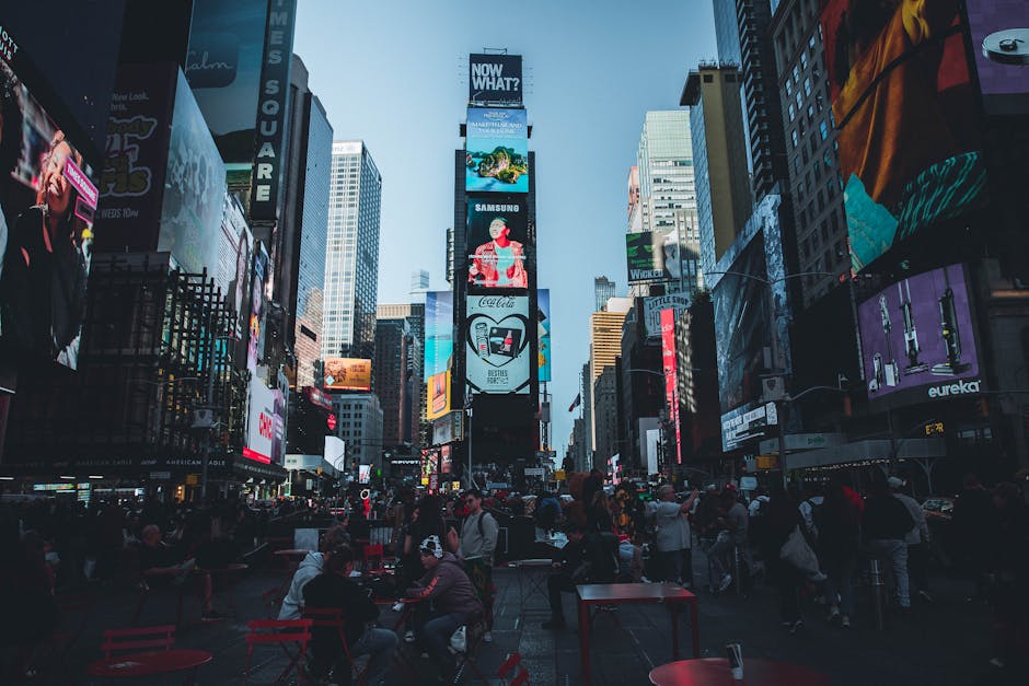 Vibrant Times Square in New York City filled with people and bright billboards during the day.