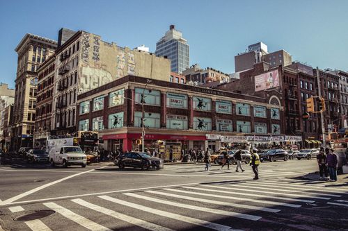 Free Dynamic street corner in New York City showcasing urban life and historic architecture. Stock Photo