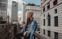 在充满活力的城市环境中，一位金发时尚年轻人正在吸烟，展现了城市的时尚氛围