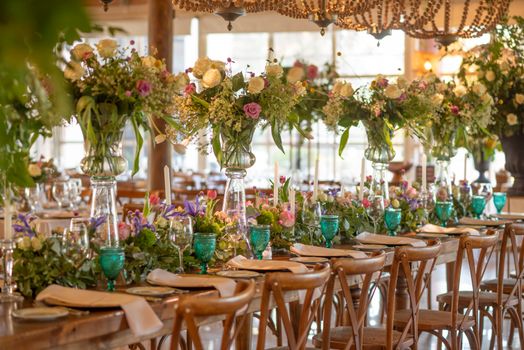 Beautifully decorated wedding table with vibrant floral centerpieces and elegant dinner settings.
