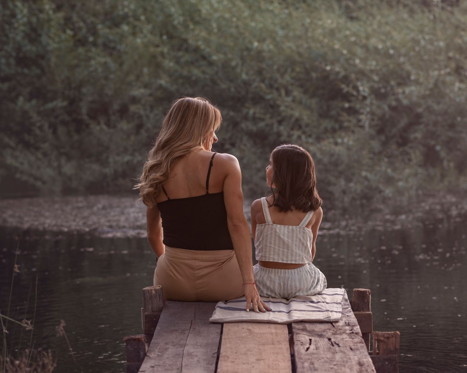 Familia en un muelle al atardecer, escena de cercanía y acompañamiento