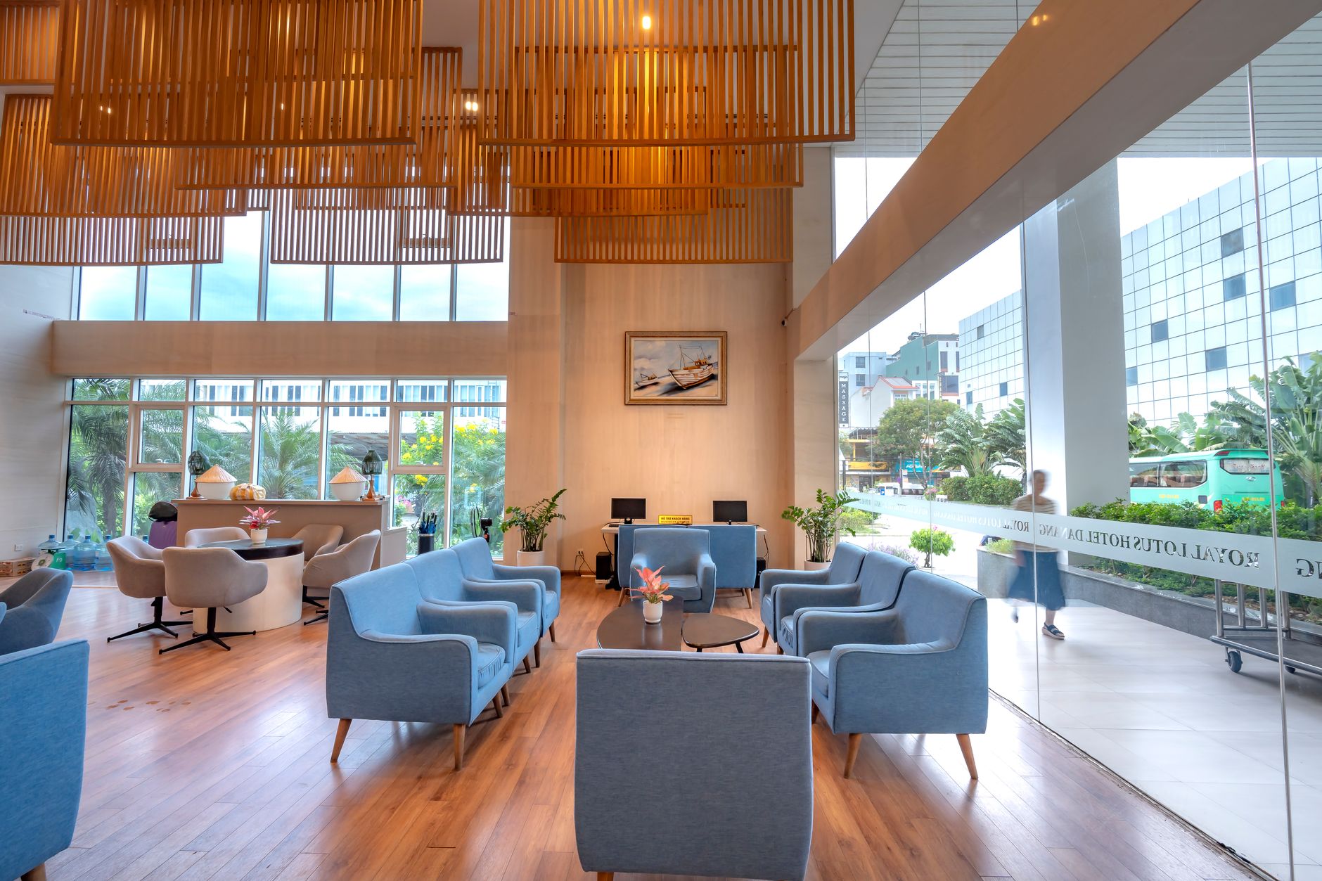 Bright hotel lobby with modern design, blue sofas, and wooden elements.