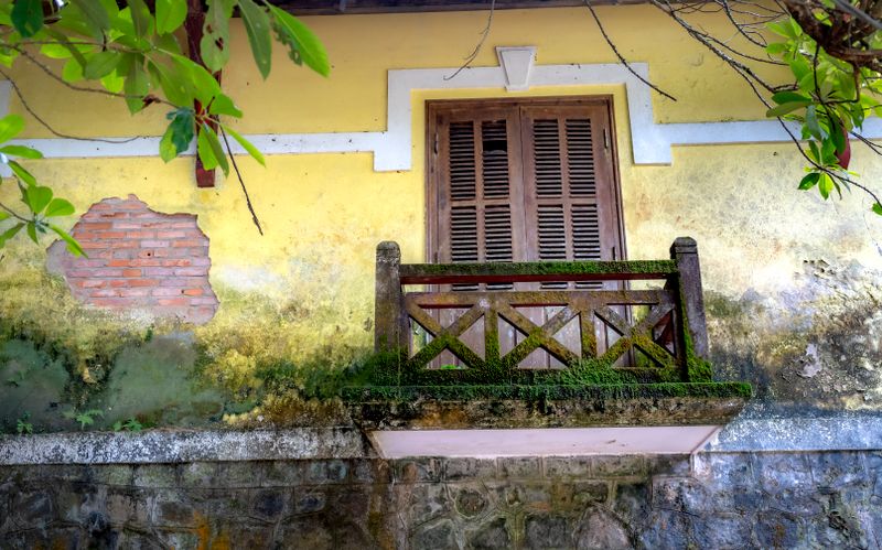 Balcon rustique avec mousse et peinture écaillée, patrimoine ancien