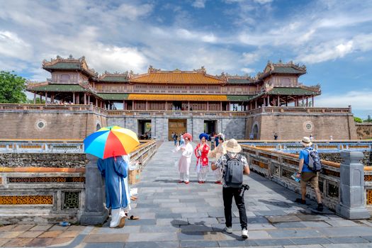 Visitors exploring the historic Imperial Citadel of Hue, Vietnam on a sunny day.