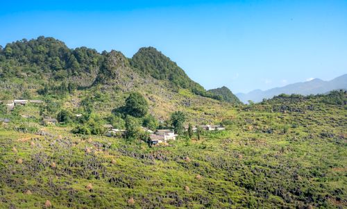 Free Beautiful view of a mountain village surrounded by lush greenery and rugged terrain. Stock Photo
