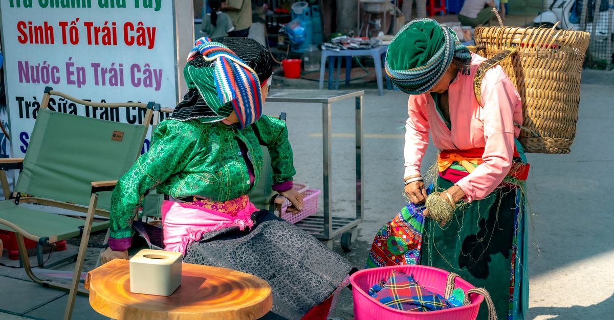 Colorful textiles and woven baskets at Ho Central Market with vendors in traditional dress