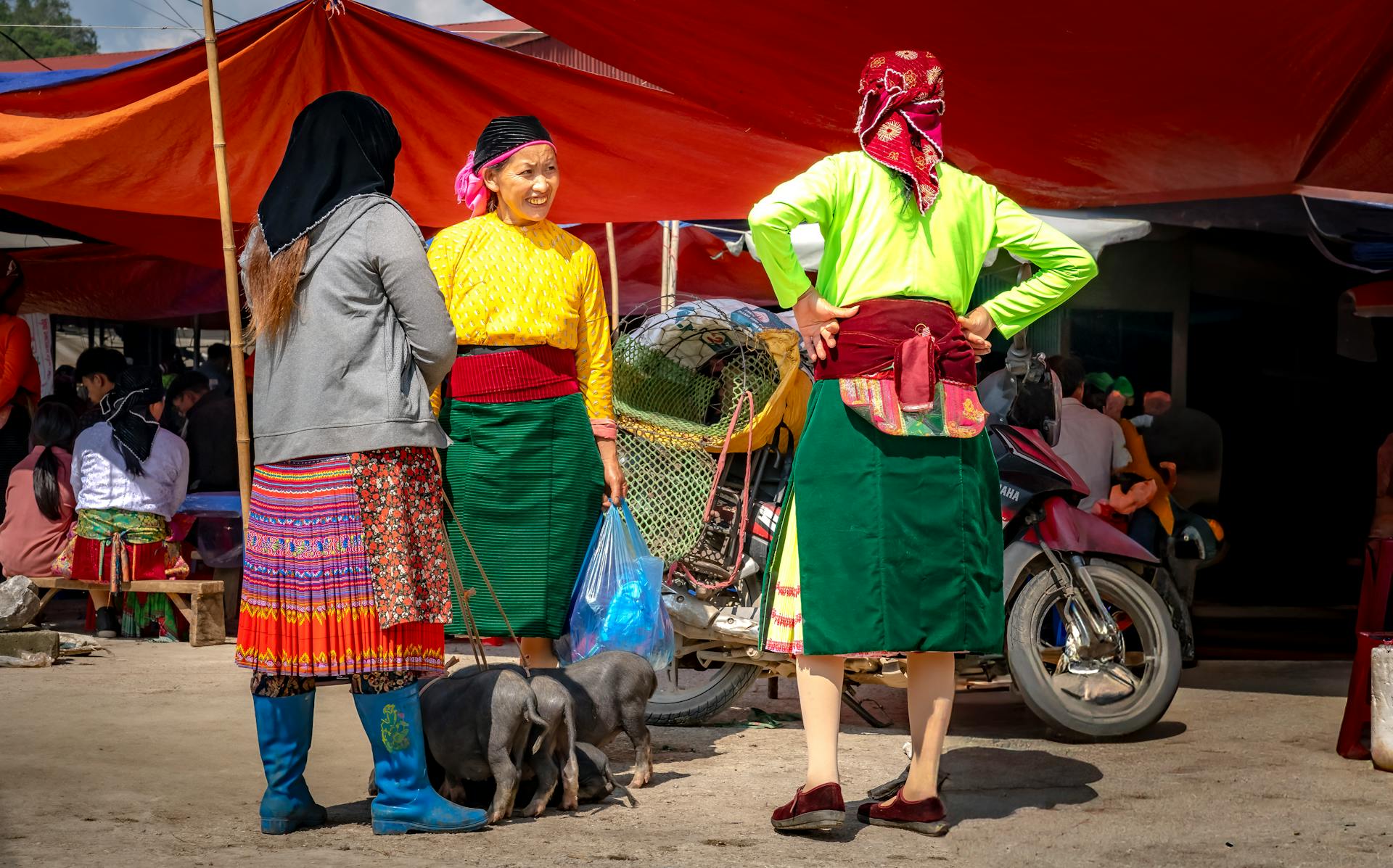 Vibrant ethnic market scene with women in traditional attire, discussing daily life.