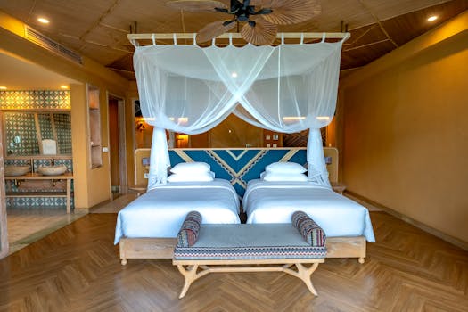 Spacious hotel room with double bed, canopy, and modern decor, perfect for tropical getaways.