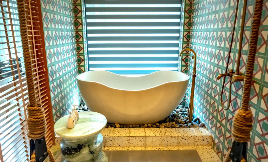 Elegant modern bathroom with a freestanding bathtub and decorative tiles, perfect for relaxation.
