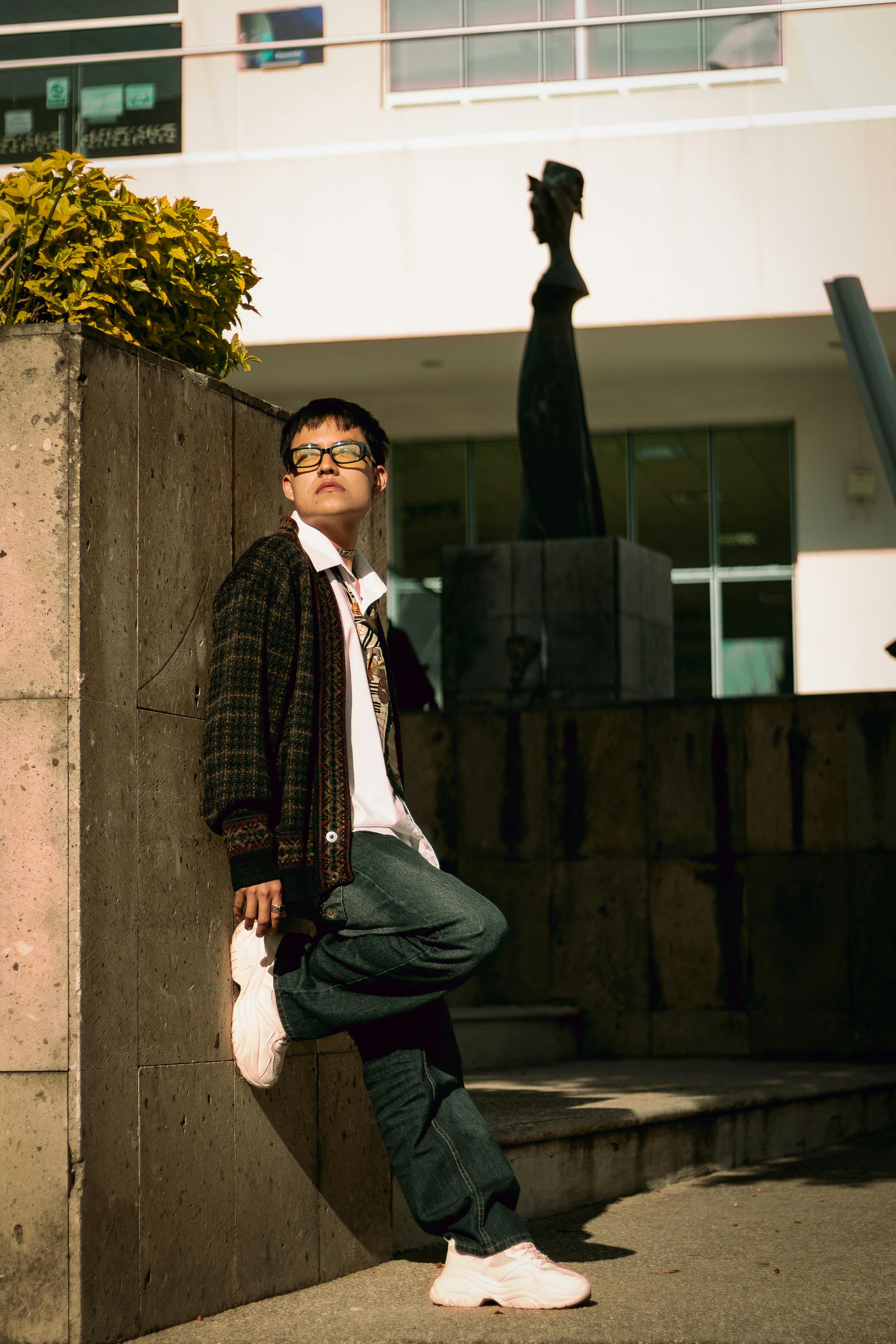 Cool portrait of a fashionable young man in natural light outside a modern building.