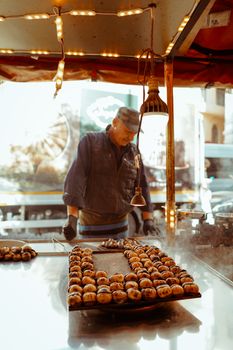 A street vendor prepares roasted chestnuts at an outdoor market in Istanbul, Turkey.
