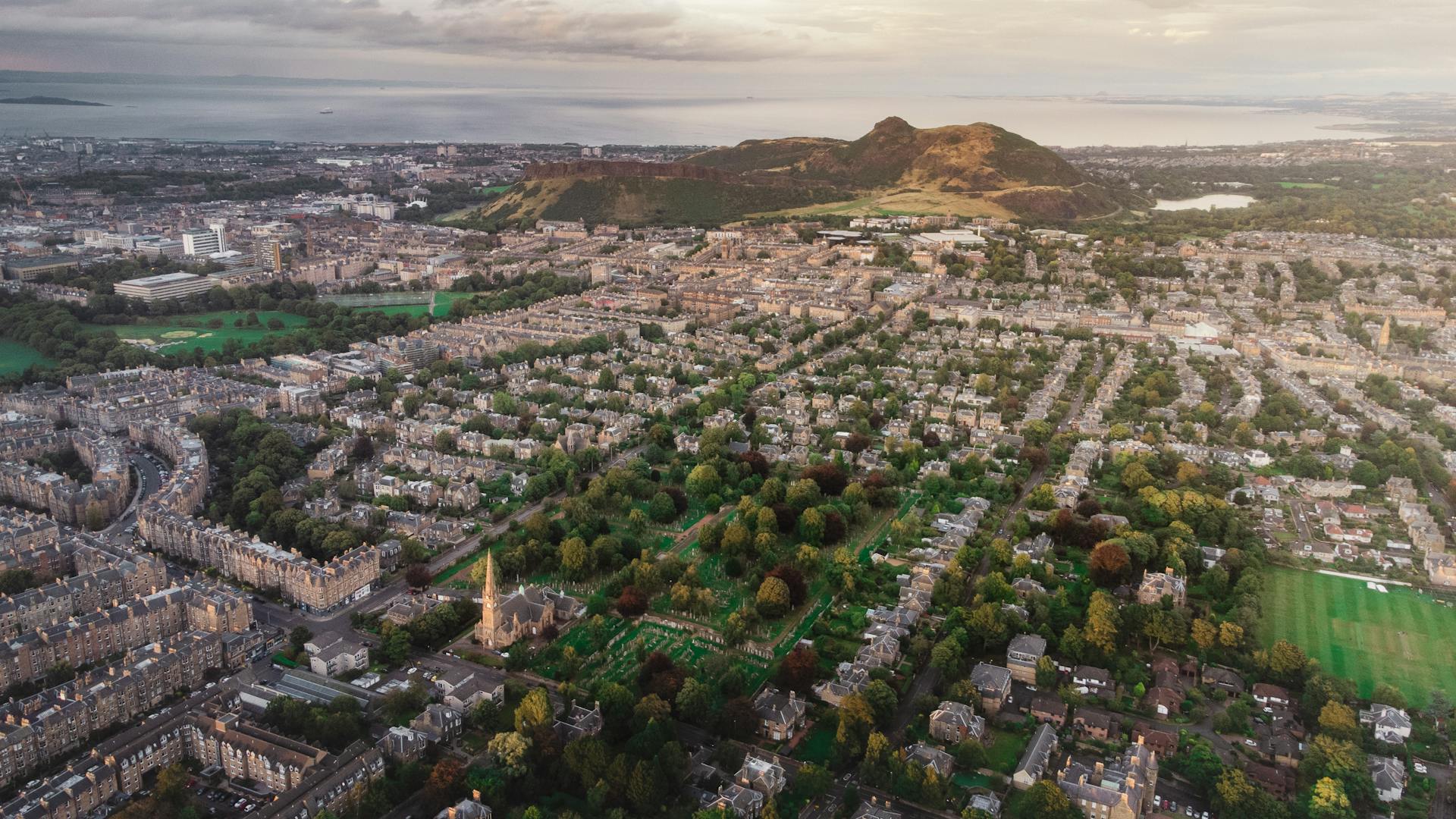 Captivating aerial shot of Edinburgh cityscape with Arthur's Seat in the background.