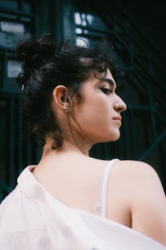 Stylish young woman in urban setting with a confident expression.