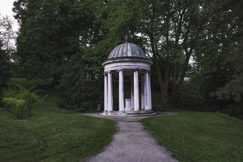 Free A classic gazebo surrounded by lush, green trees in a peaceful park setting. Stock Photo