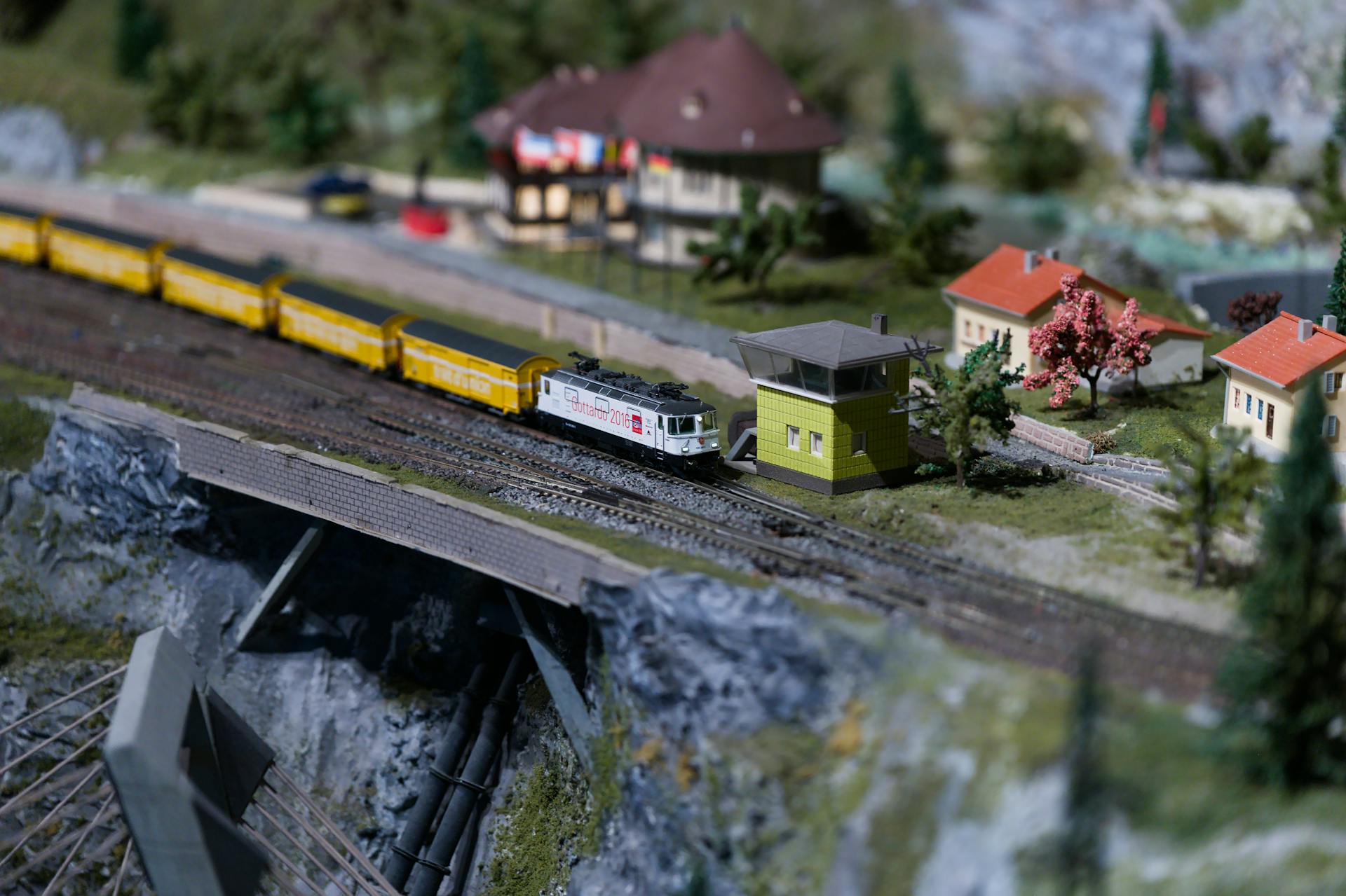 Miniature Model Railway Scene with Train Crossing Bridge