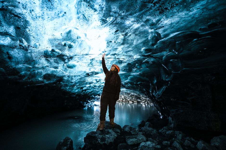 A mesmerizing view of a person exploring the vivid blue ice caves in Iceland.