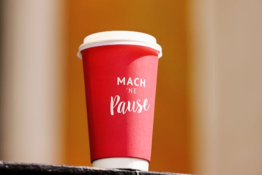 Red coffee cup with 'Mach ne Pause' inscription, perfect for a coffee break concept.