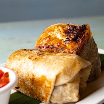 Close-up of a tasty grilled burrito with crispy, savory filling.