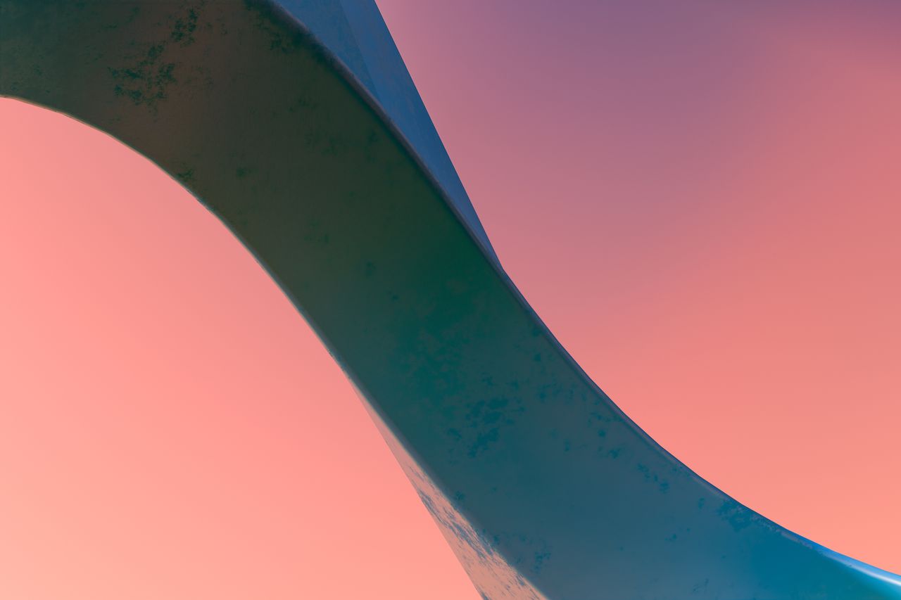 an elegant abstract sculpture with flowing lines against a vibrant sun