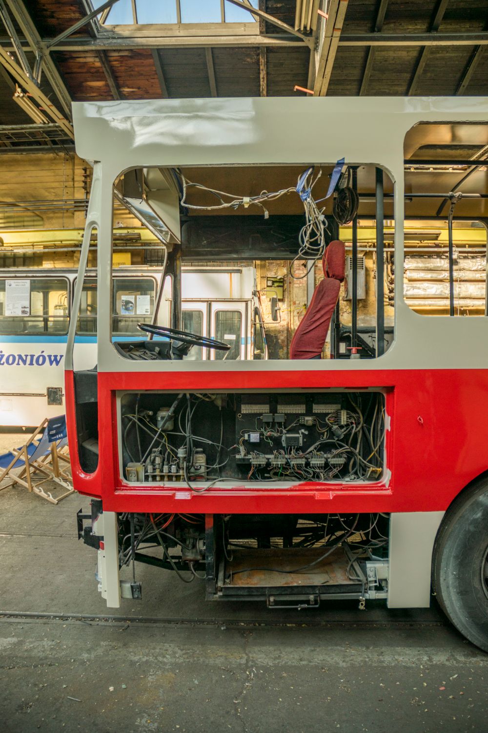 Bus body stripped to its frame inside a workshop