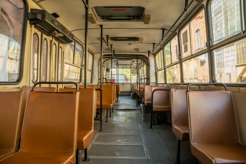Free Interior view of a vintage tram showing empty brown seats under warm sunlight in Wrocław, Poland. Stock Photo