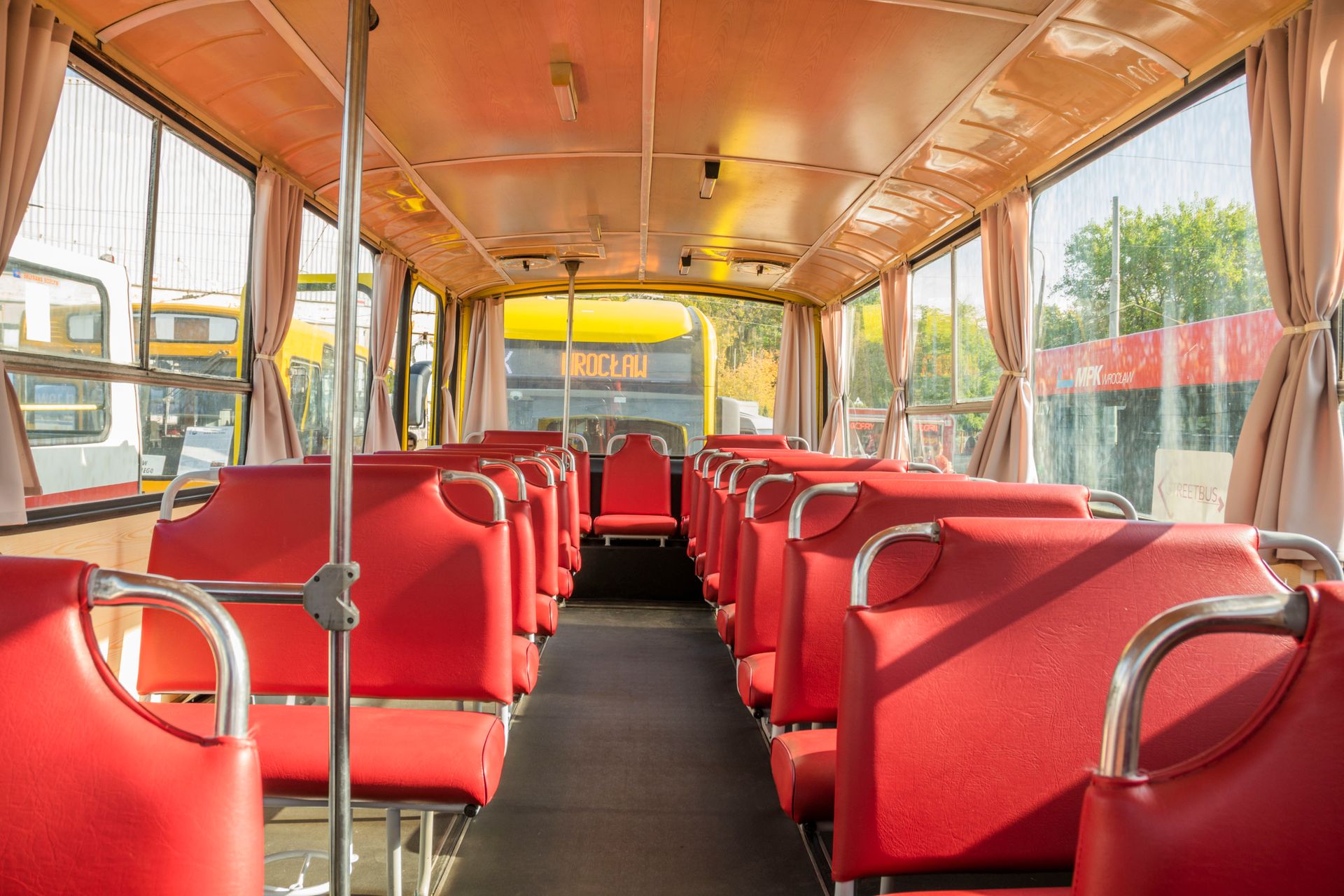 The inside view of an empty bus with red seats in Wrocław, Poland.