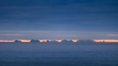 Dramatic sunrise over sea and islands in Nordland, Norway, capturing nature's beauty.
