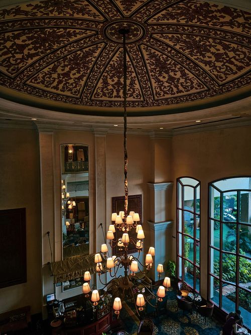 Free Luxurious hotel lobby in New Delhi featuring a grand chandelier and decorative ceiling. Stock Photo
