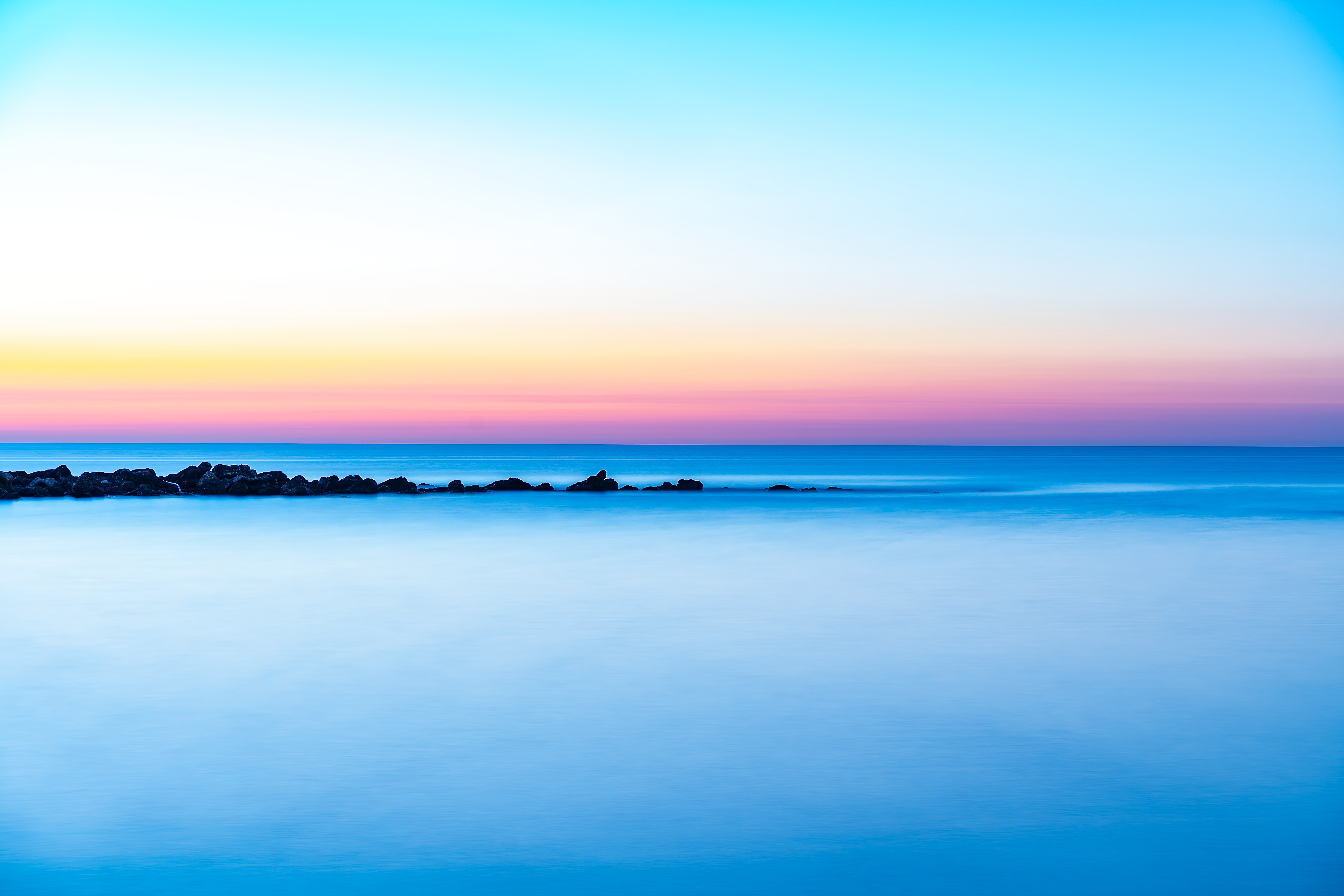 Fotomural Un amanecer sereno sobre el Mar Mediterráneo con aguas tranquilas y colores vibrantes, Comunidad Valenciana, España.