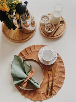 A sophisticated breakfast setup with elegant dishware, golden utensils, and decorative elements.