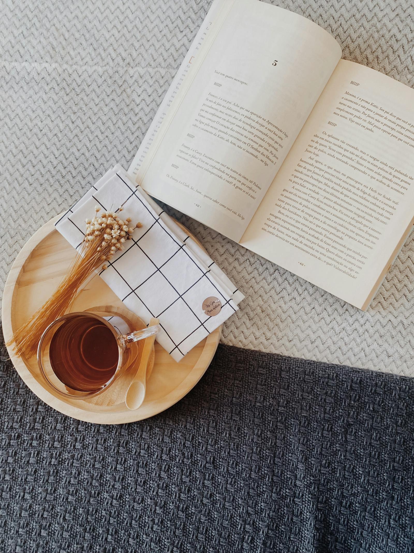 Angolo lettura con libro aperto e tazza di tè su coperta
