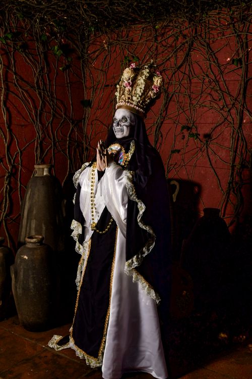 Free Figure in a dark environment wearing ornate costume and skull makeup. Stock Photo