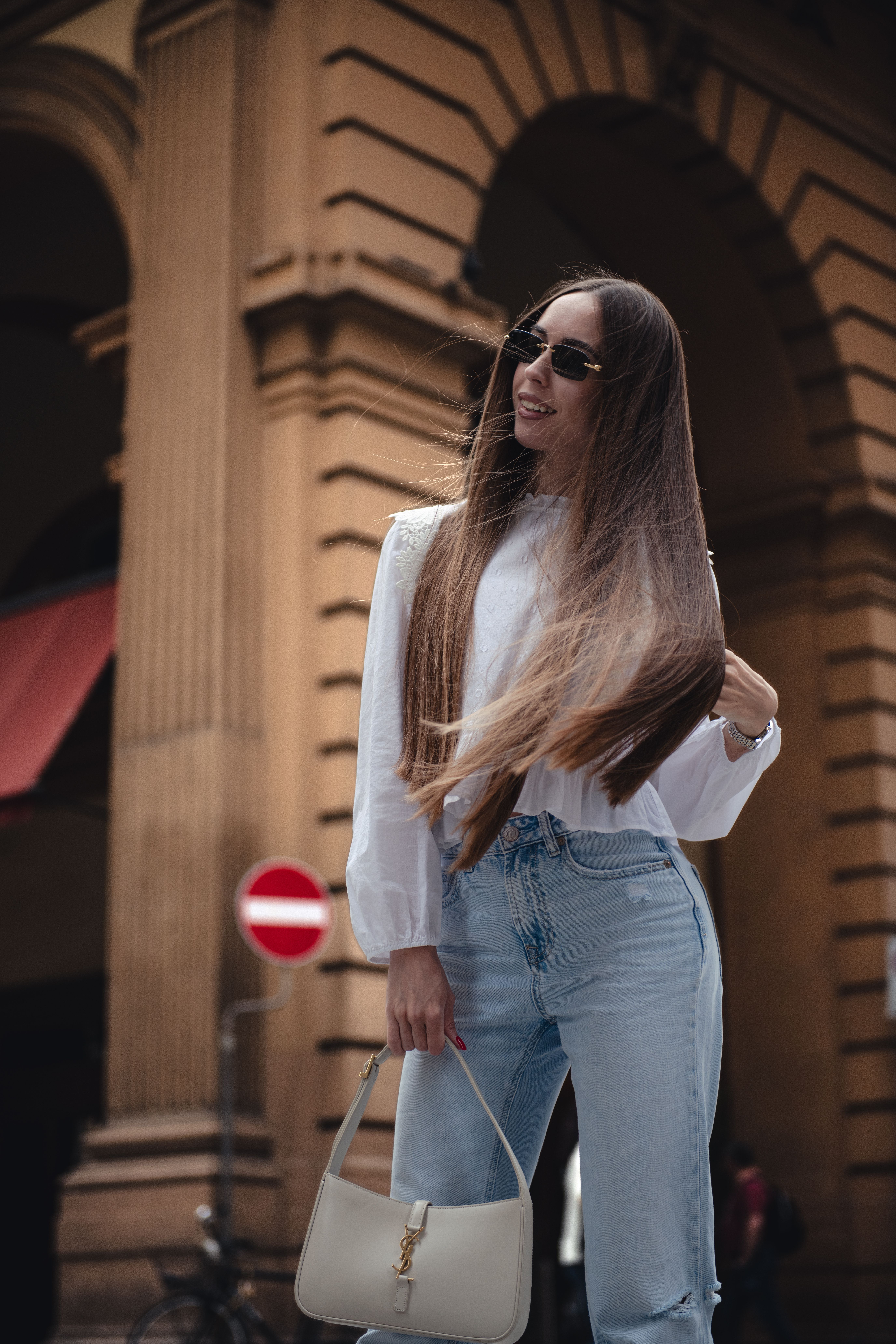 A trendy woman with sunglasses in Florence, Italy, captures urban fashion vibes.