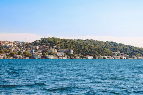 Free A picturesque view of Istanbul's coastline along the Bosphorus with lush hills and urban skyline. Stock Photo