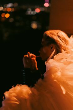 Silhouette of a woman in elegant attire against a night cityscape, exuding sophistication.