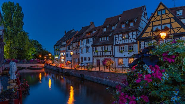 Beautiful evening view of half-timbered houses along a canal in Colmar, France.