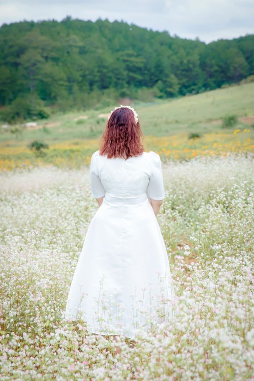Bride in Floral Meadow with Verdant Hills · Free Stock Photo