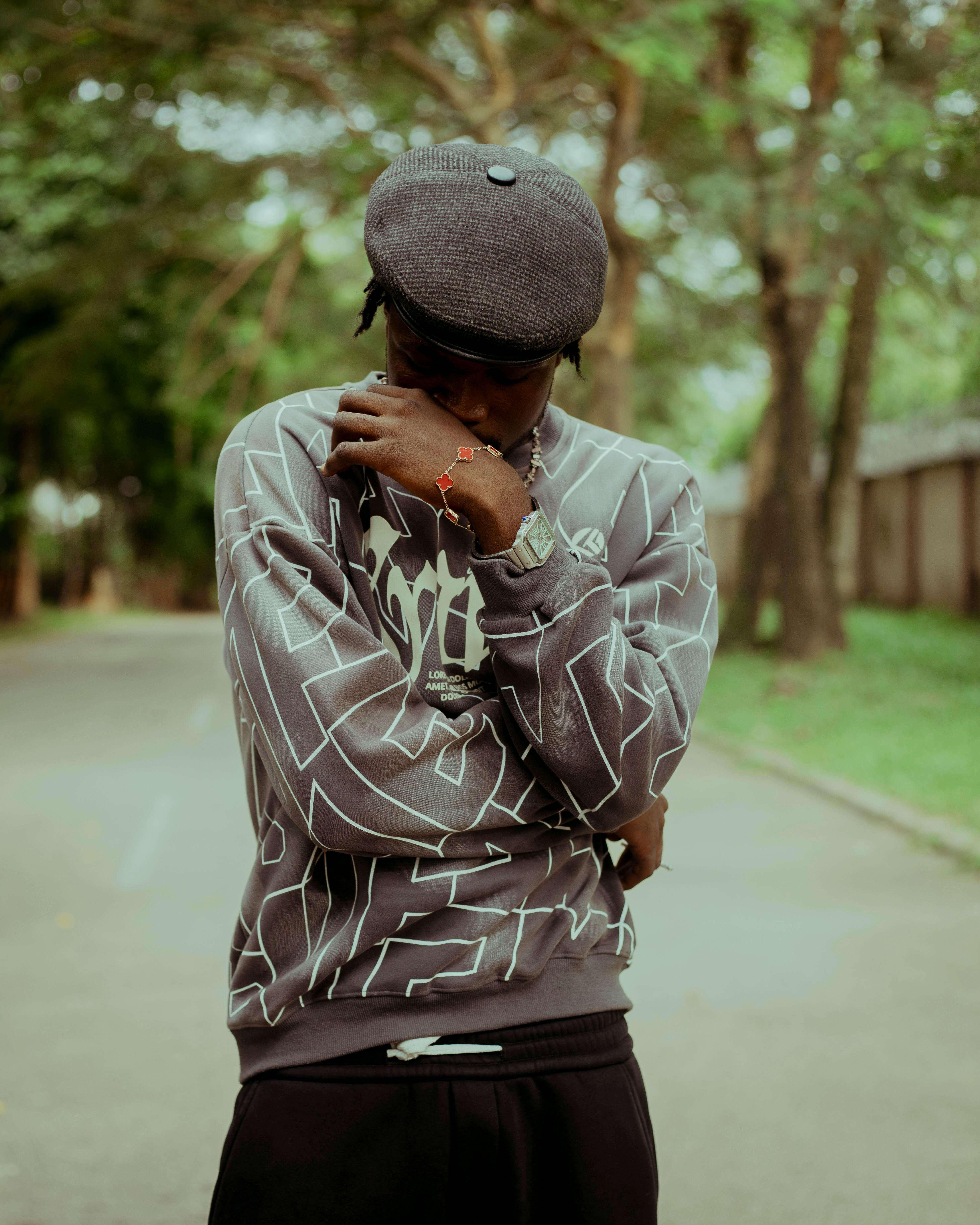 Free A young man in casual street fashion poses in a serene outdoor setting, showcasing modern style. Stock Photo