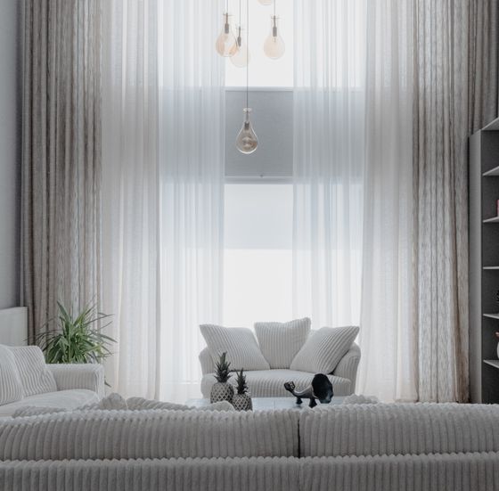 Minimal living room with sheer curtains and pale sofas — photo by Beyza Kılıçdere on Pexels