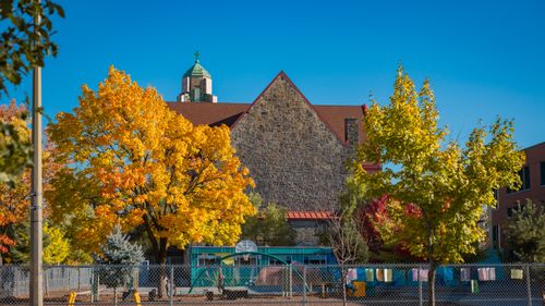 Free Colorful autumn trees frame a Catholic church in Montreal, showcasing vibrant fall colors. Stock Photo
