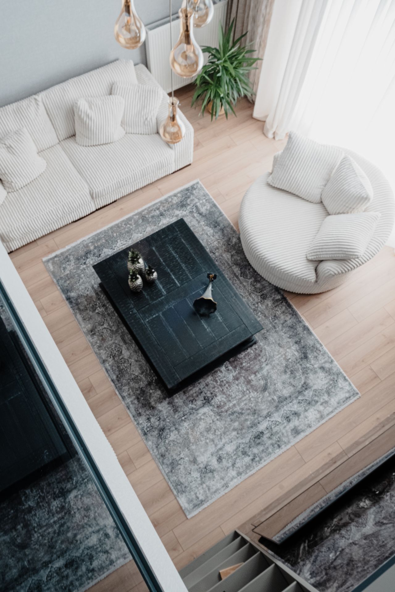 Overhead view of a living room with an area rug anchoring the seating zone