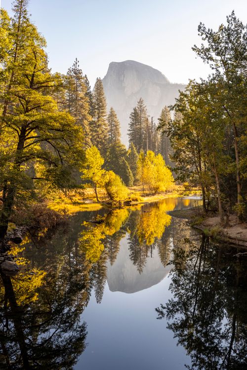 Free Scenic view of Half Dome reflecting in a tranquil river at Yosemite in fall. Stock Photo