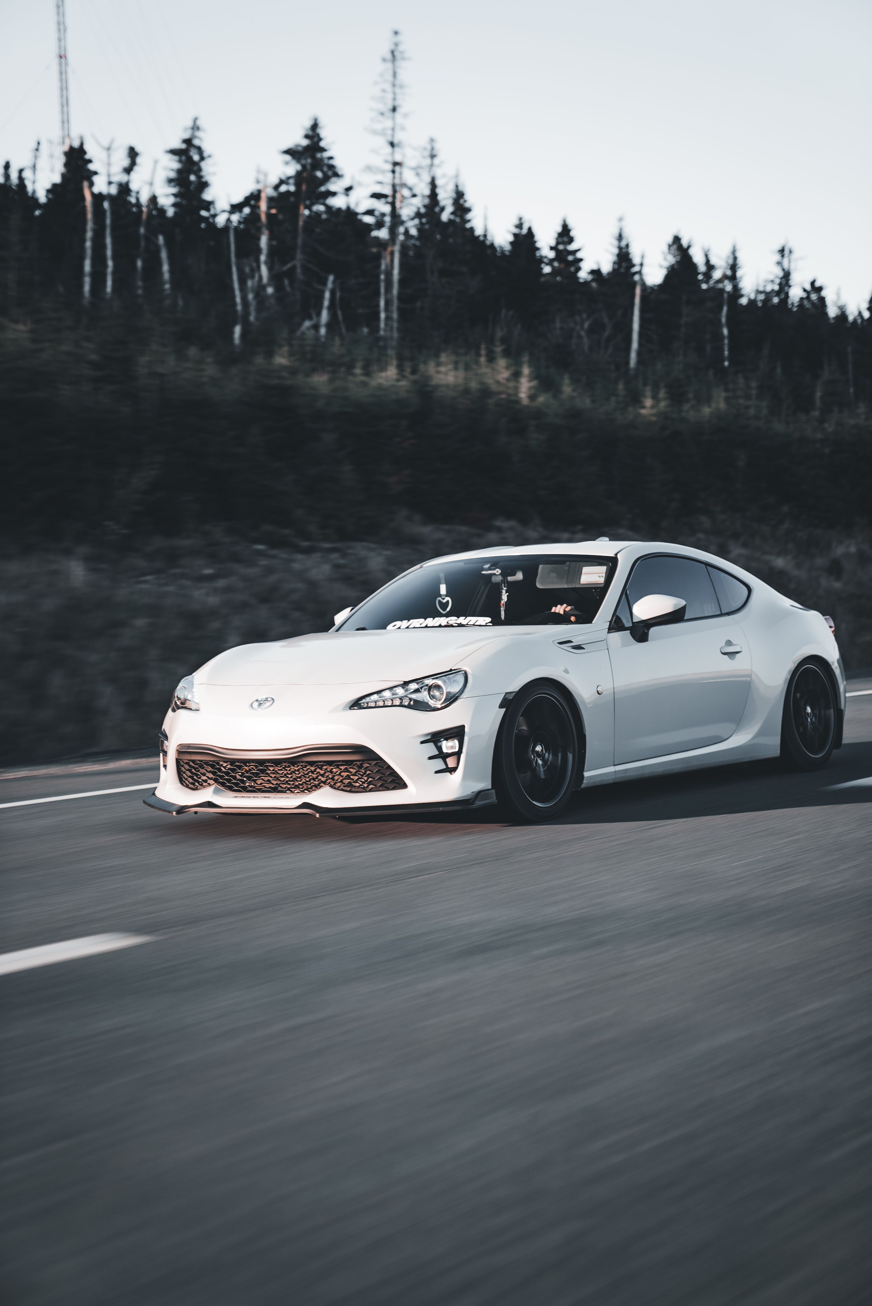 Sleek White Sports Car on a Scenic Highway · Free Stock Photo