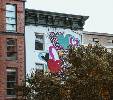 Vibrant street art mural with heart motifs on a New York building facade.